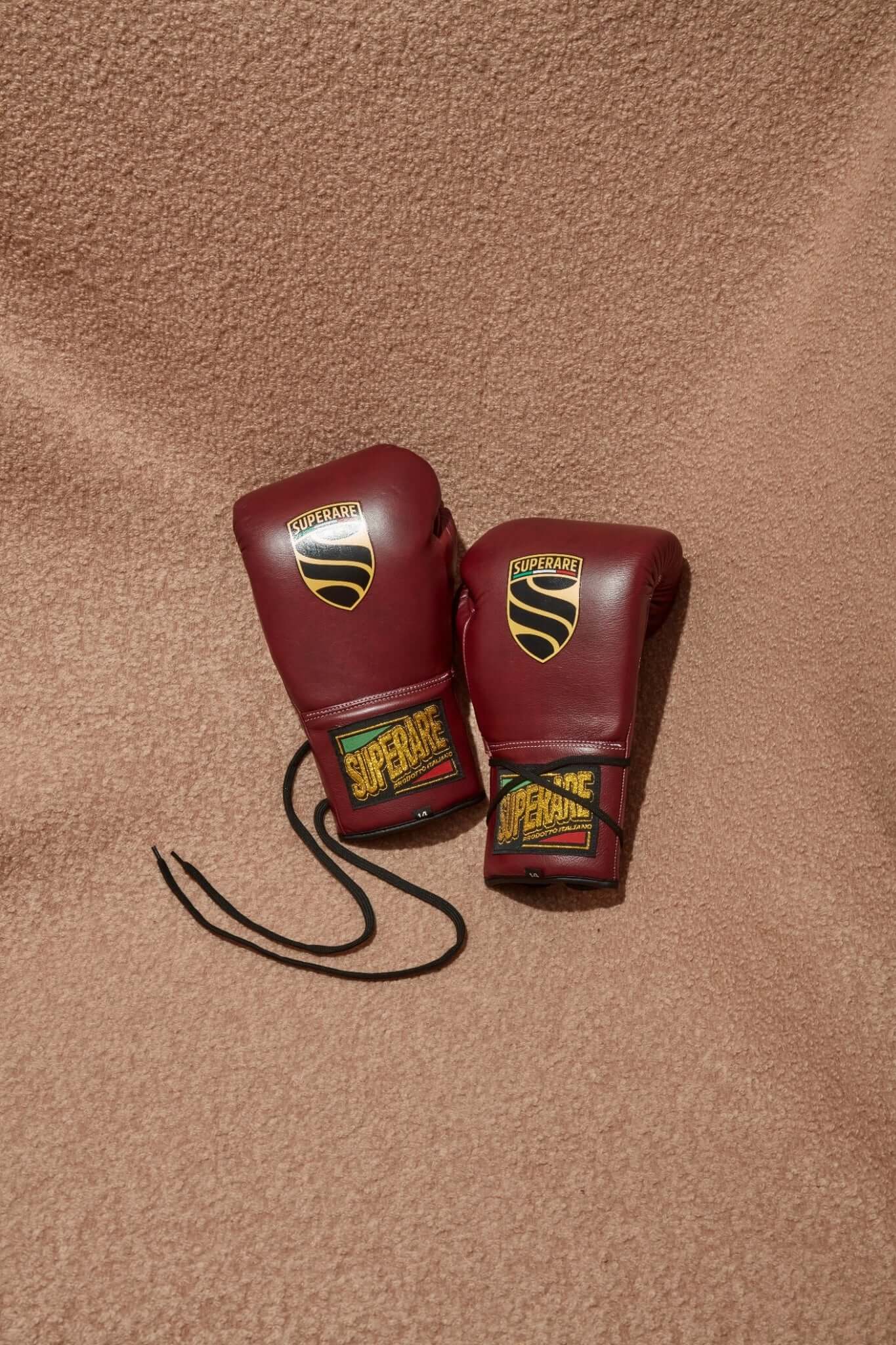 Superare S40 Boxing Gloves in Amarena Purple on a textured background, made with premium Italian leather.