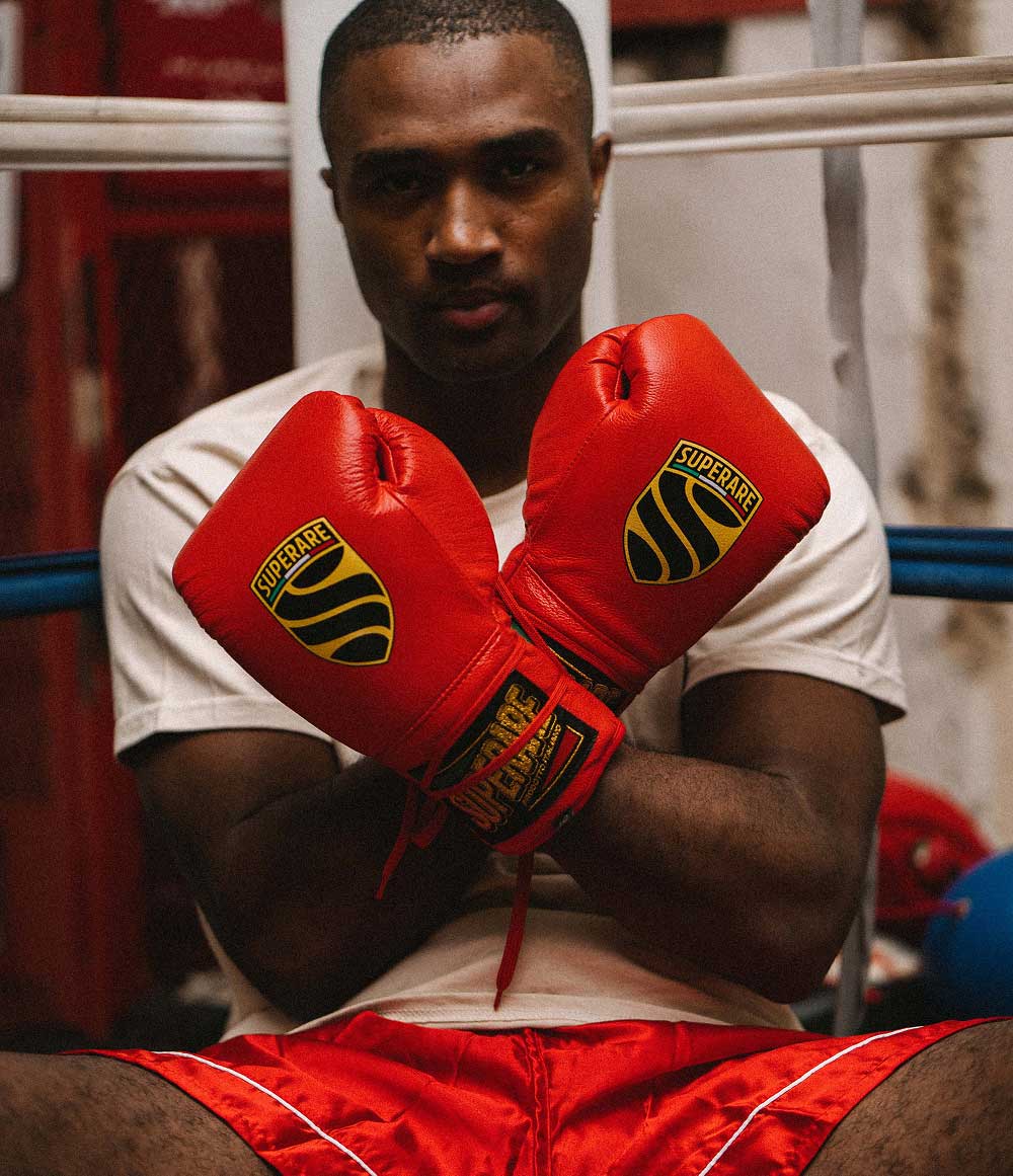 Athlete in boxing gloves by Superare, showcasing the collaboration with Paragon x Ronin, set in a boxing gym.
