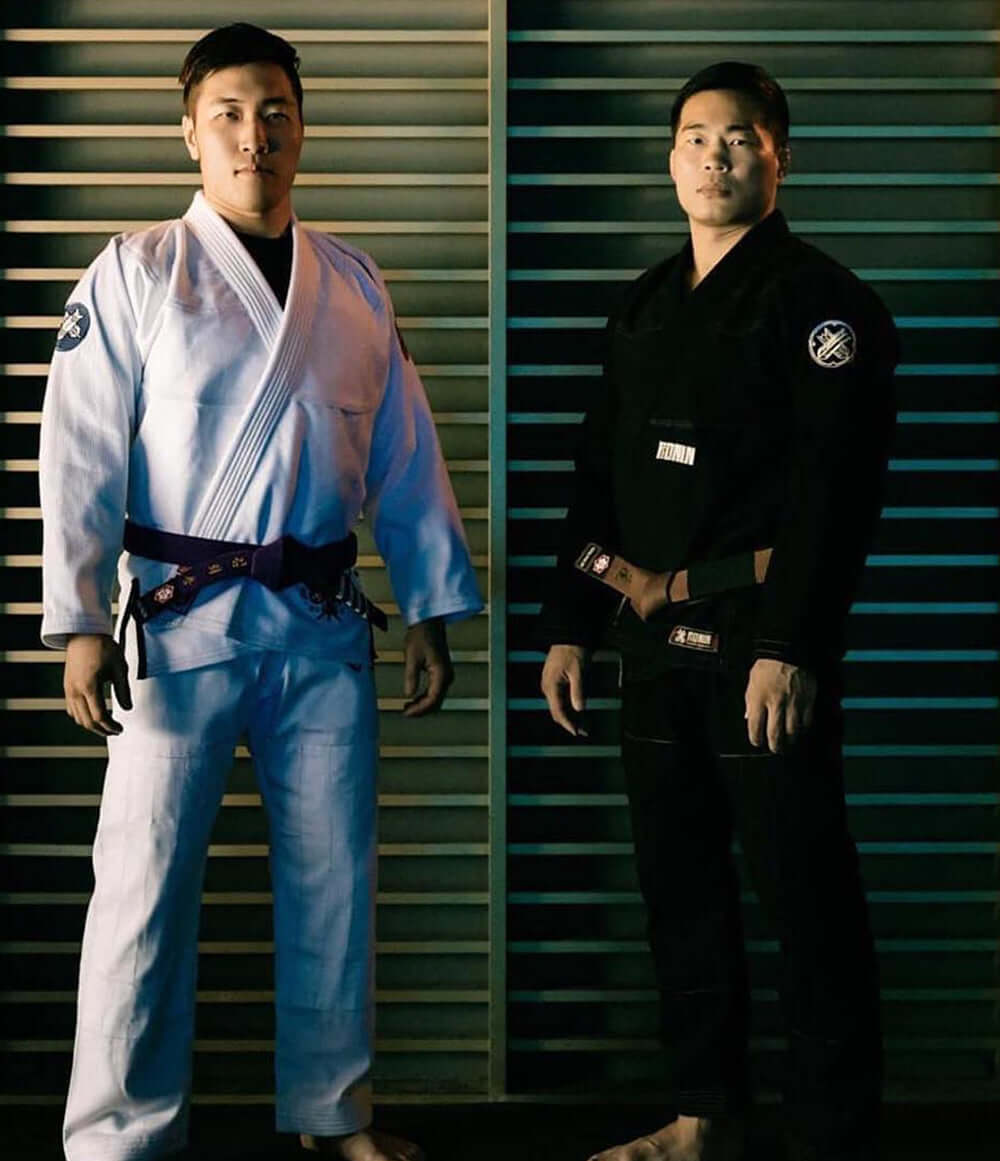 Two martial artists in BJJ gis, one in white and one in black, showcasing the blend of BJJ and Boxing at Paragon x Superare x Ronin.