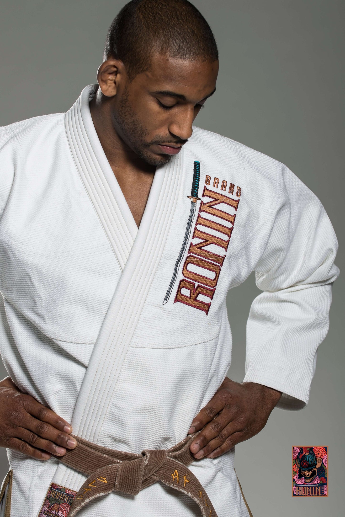 Man wearing Roninbrand Emperor BJJ Gi in white, showcasing its design and embroidered logo for Brazilian Jiu Jitsu.