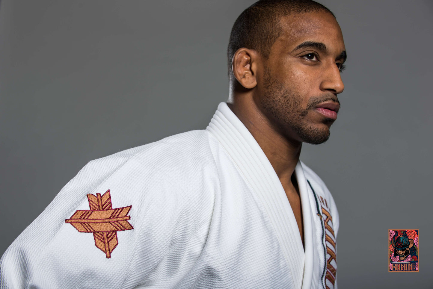 Man wearing Roninbrand Emperor BJJ Gi in white, showcasing intricate chrysanthemum embroidery for Brazilian Jiu Jitsu.