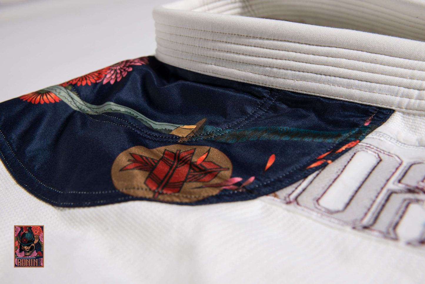 BJJ Gi Paragon Elite Fight x Ronin Emperor - White (Imperial Break) collar detail with floral design and emblem.