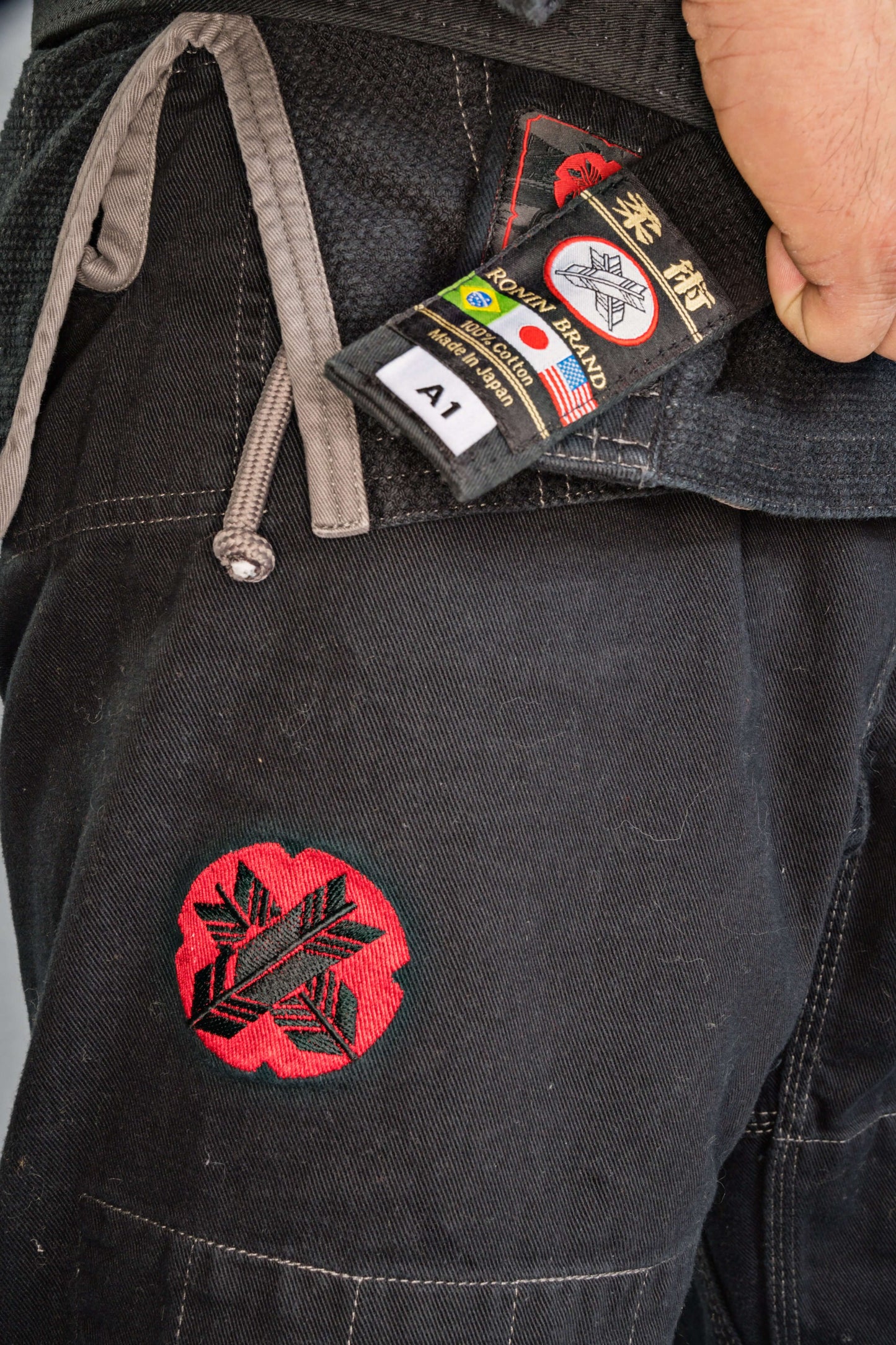 Close-up of Roninbrand Samurai Ghost BJJ Gi with tag and embroidered design, showcasing comfort and quality in black.