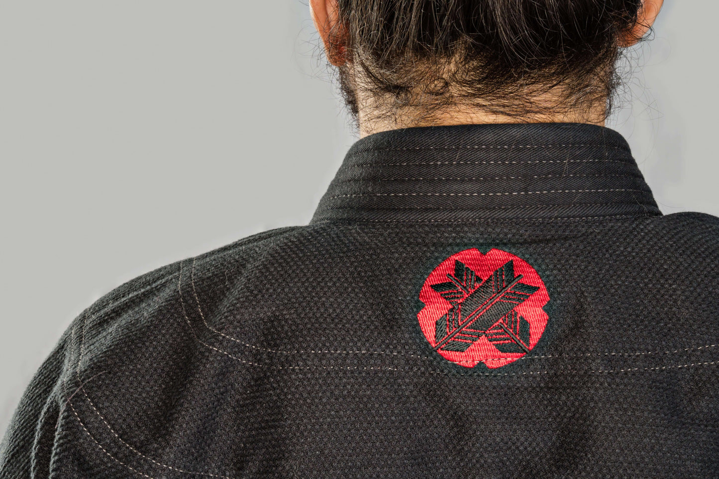 Back view of Roninbrand Samurai Ghost BJJ Gi, featuring a striking red logo on black fabric, designed for elite fighters.