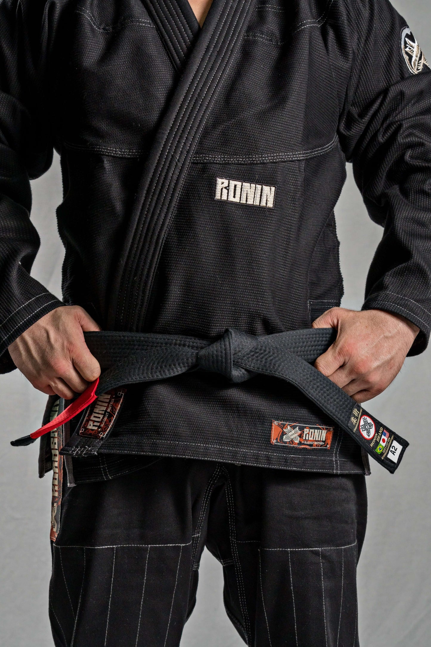 Close-up of a fighter in a black Roninbrand BJJ Gi, tying a black belt, showcasing premium craftsmanship and comfort.