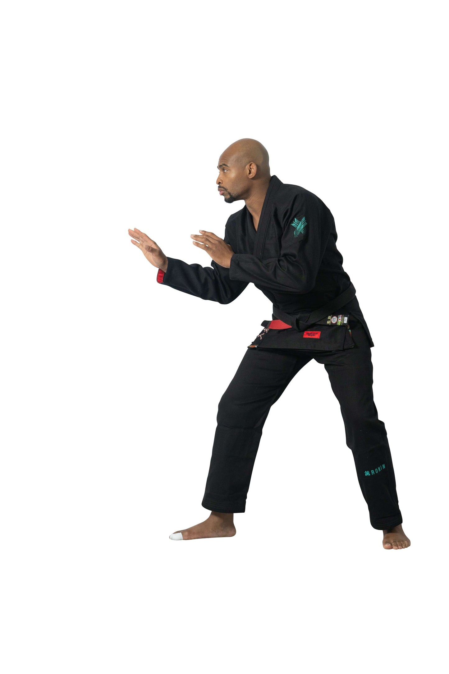 Male practitioner in Roninbrand Shinsei Yugure BJJ Gi - Black showcases grappling stance and technique.