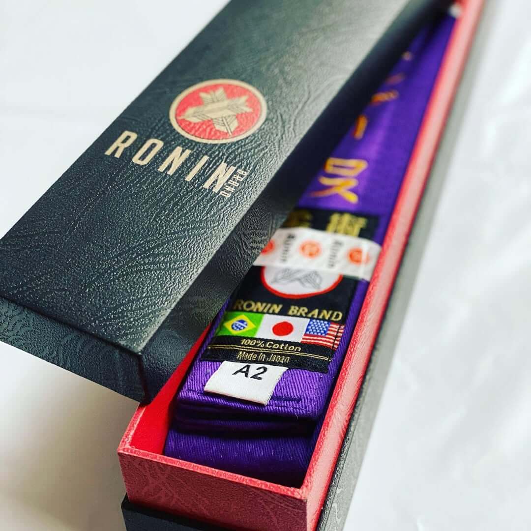 BJJ Belt System featuring a purple belt in a Ronin brand box, representing progression in Brazilian Jiu-Jitsu.