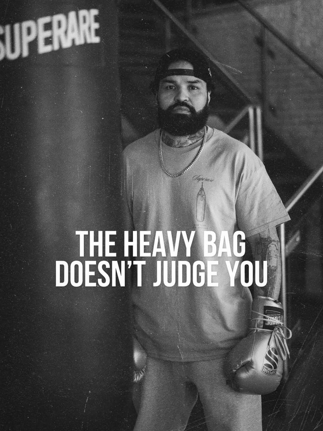 Bokshandschoenen in gebruik tijdens training met zware boksbal, inspirerende kracht van de bokser.