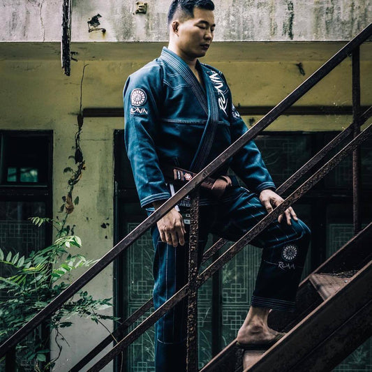 BJJ practitioner descending stairs in blue gi, showcasing traditional martial arts attire and dedication to training.