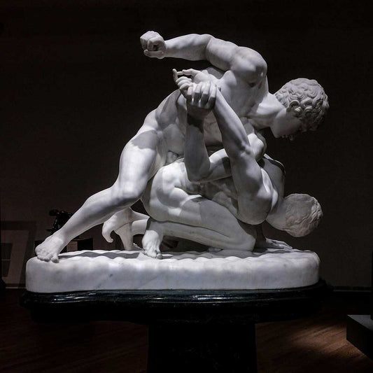 Marble sculpture depicting two ancient warriors engaged in a wrestling match, showcasing the history of combat sports.