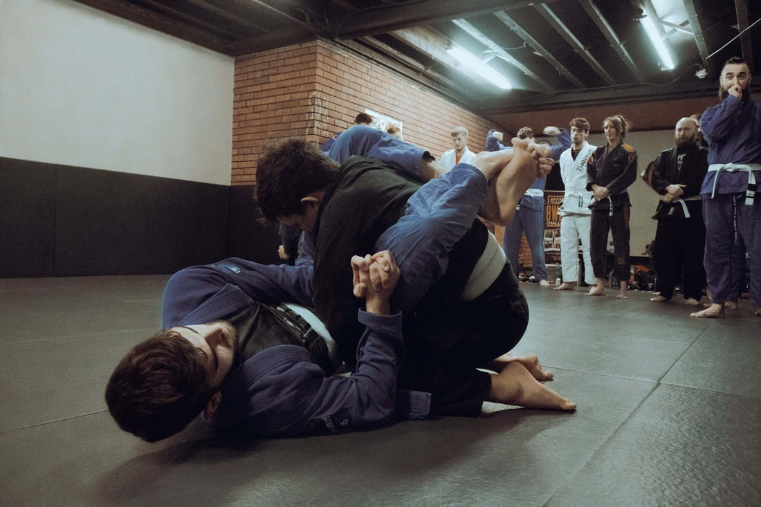 Two practitioners grappling in BJJ gis showcasing BJJ gi technology innovations in a training session.