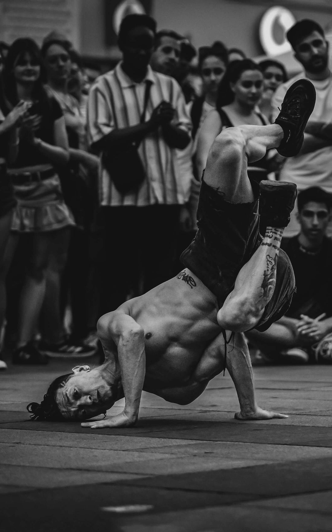 Fight performance captured in a street dance battle with applauding crowd in the background.