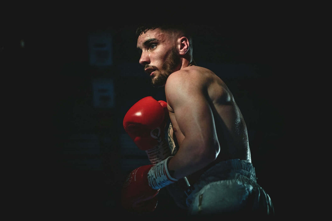 A determined fighter wearing red boxing gloves, representing the fight in the ring.