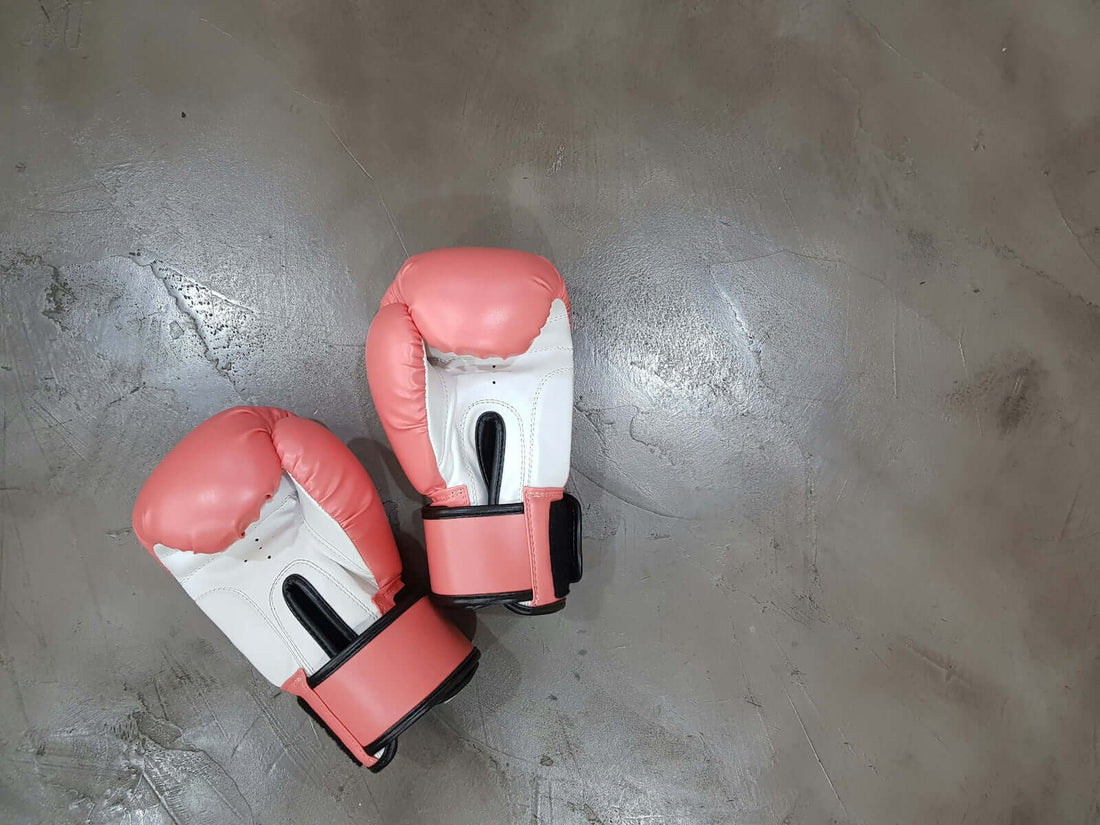 Boxing gloves on a concrete surface, essential for optimizing your boxing experience.