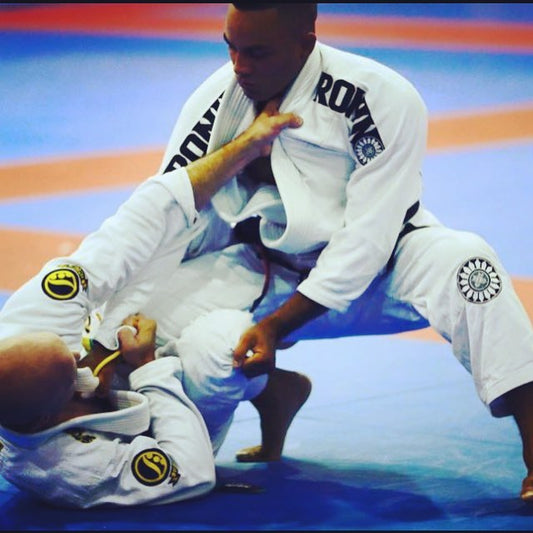 Two Brazilian Jiu-Jitsu practitioners sparring on the mat, showcasing techniques and athleticism.
