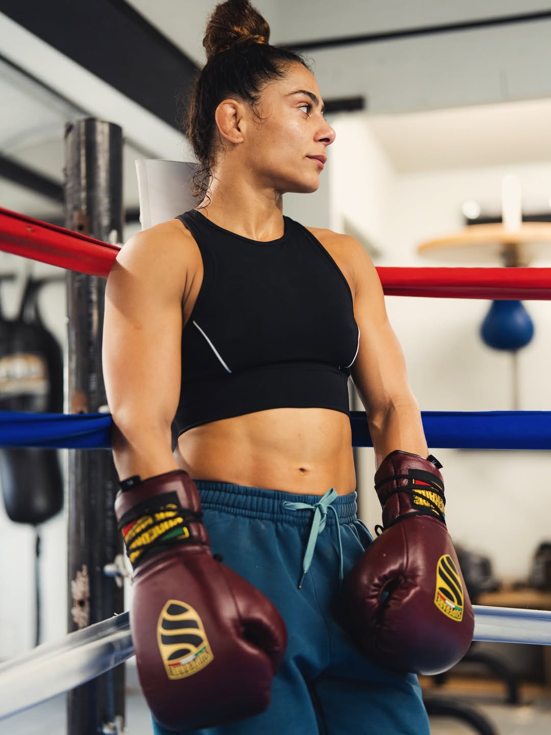 Focused fighter ready for the Fight, wearing boxing gloves and training attire in the ring.
