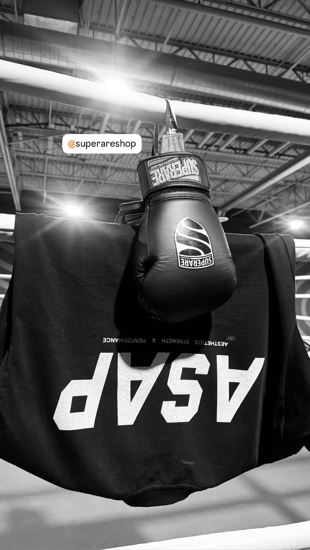 Boxing glove hanging on a shirt in a training gym, showcasing boxing gear and equipment.