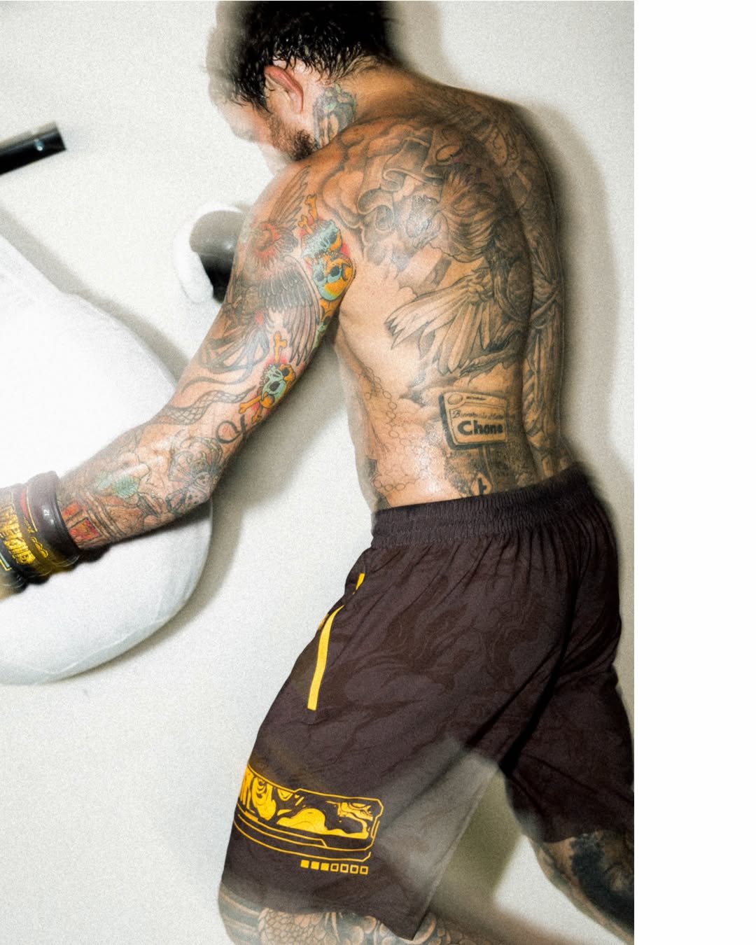 Fight training session featuring a tattooed boxer hitting a punching bag.
