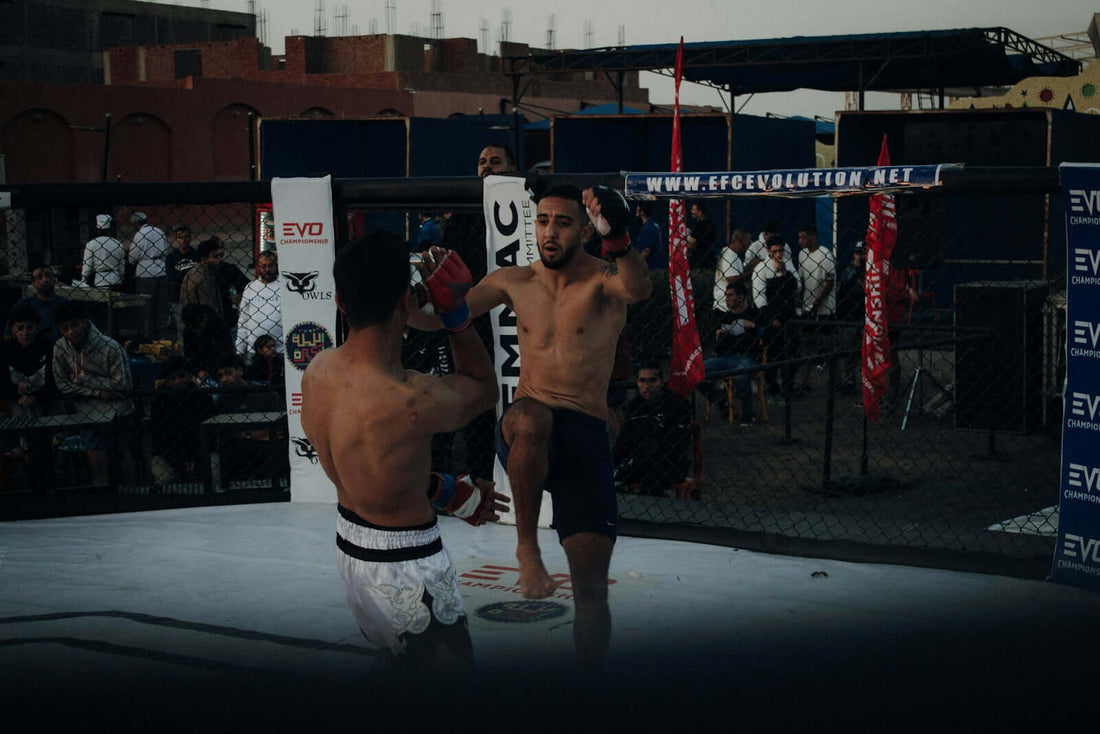 BJJ practitioners sparring in an MMA cage, demonstrating techniques related to Brazilian Jiu-Jitsu.