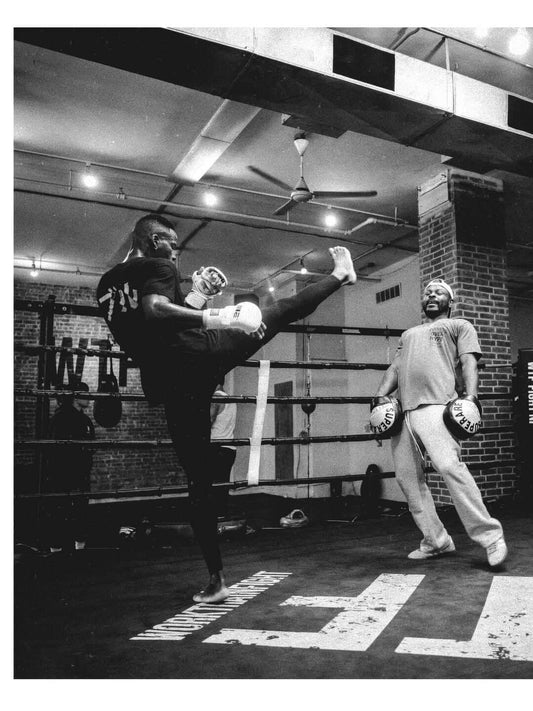 Training session with boxing gloves in a gym, showcasing two boxers practicing techniques.