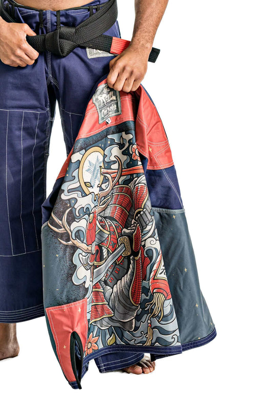 BJJ practitioner holding a colorful gi featuring a samurai design, showcasing BJJ culture and style.