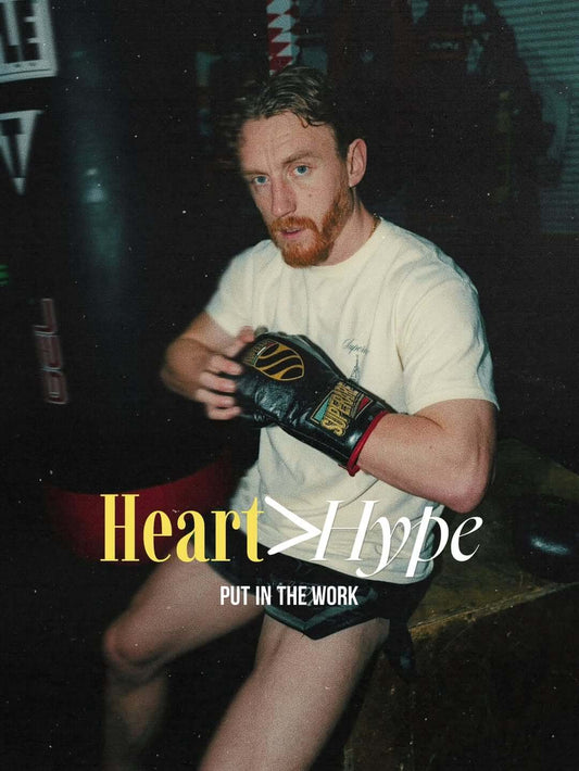 Boxer in gym with gloves, emphasizing hard work over hype, showcasing dedication to training