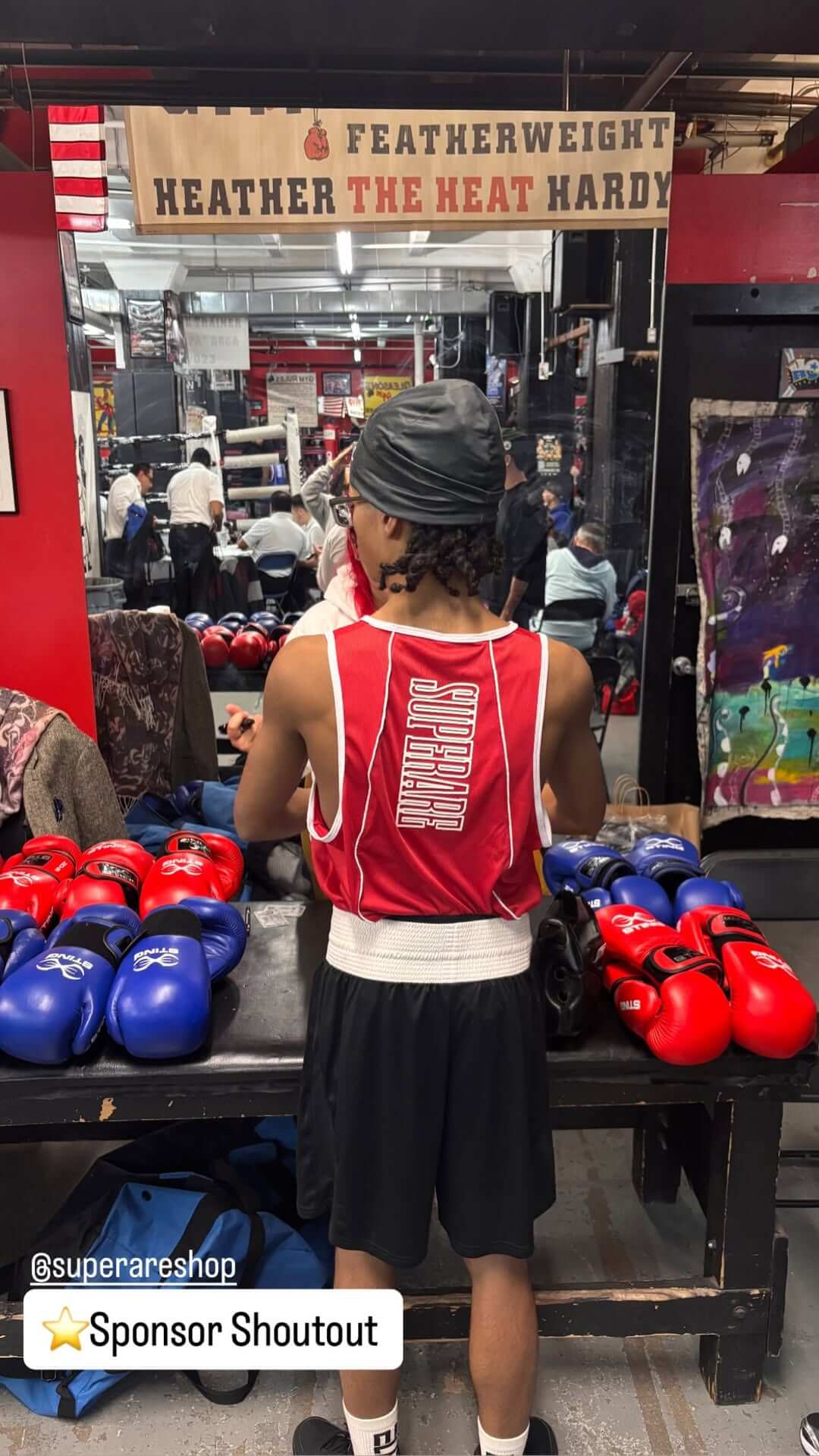 Paragon Elite Fight boxing gloves displayed on a table with a boxer in training.