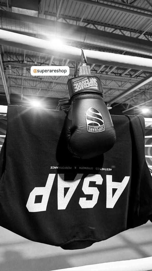 Boxing glove hanging on a shirt in a training gym, showcasing boxing gear and equipment.