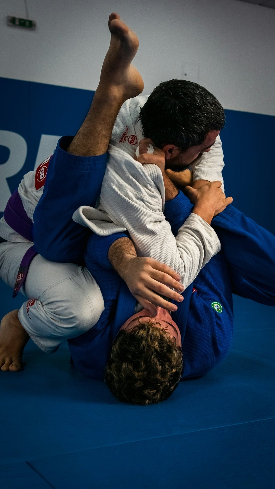 Two Brazilian Jiu-Jitsu practitioners demonstrating fighting techniques on the mat.