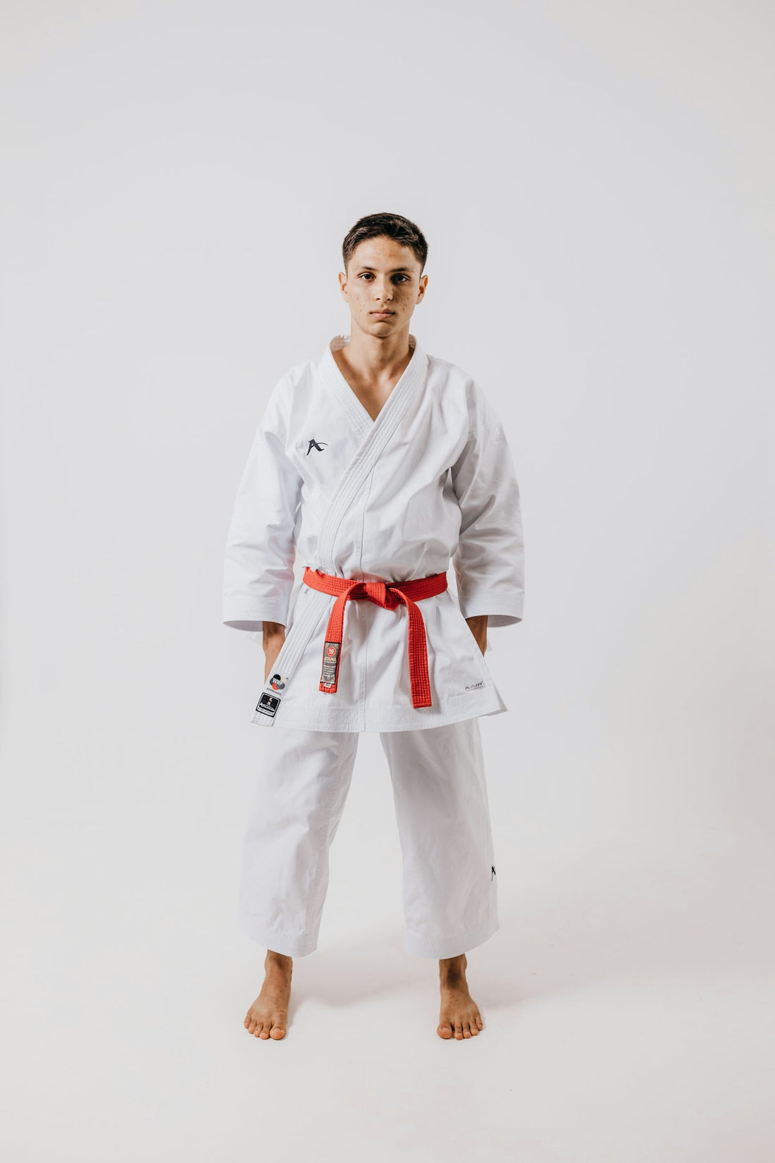 Fight - a martial artist in a white gi with a red belt, showcasing essential qualities of professional BJJ gis