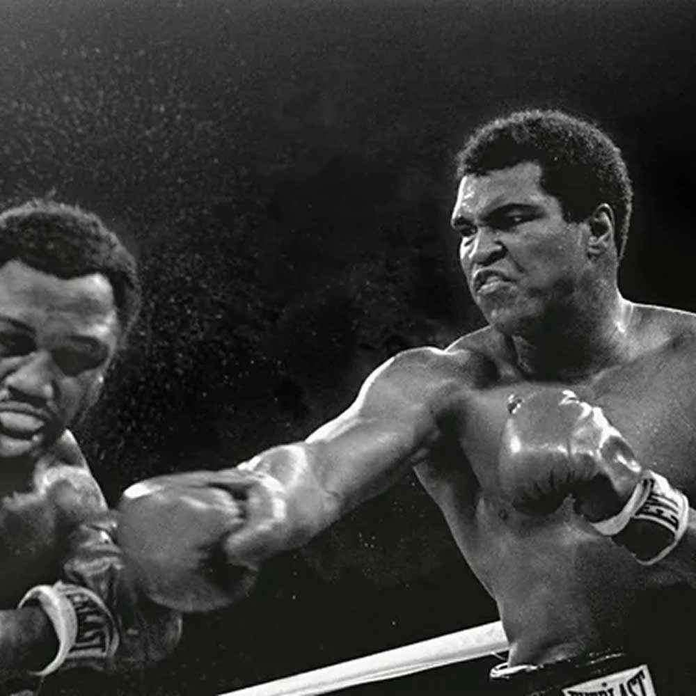 Muhammad Ali delivering a powerful punch to Joe Frazier during the iconic 1975 boxing match in Manila.