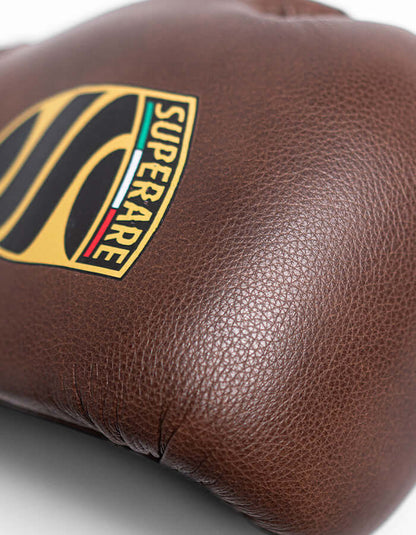 Close-up of Superare S50 boxing gloves in charcoal brown Italian leather, showcasing quality craftsmanship and logo.