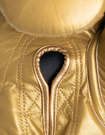 Close-up of Superare S50 gold boxing gloves showcasing premium Italian leather craftsmanship.