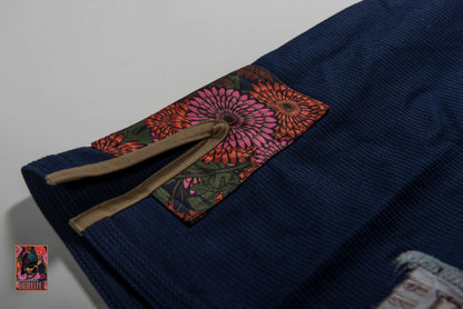 Detail view of Roninbrand Navy Emperor BJJ Gi featuring unique floral patch and textured fabric for enhanced performance.