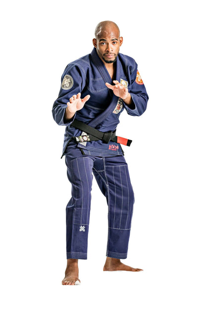 Male practitioner in Roninbrand Oni Bushi Navy BJJ gi demonstrating a martial arts stance, showcasing professional fight gear.