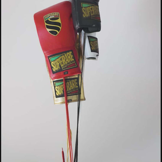 Superare boxing gloves in red and black held by a hand, showcasing quality and design for professional fighters.