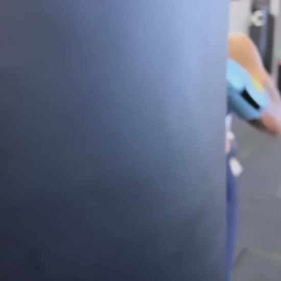 Person practicing boxing moves with Superare S40 Cielo Sky Blue gloves against a training bag.