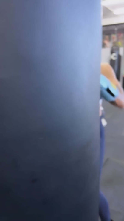 Person practicing boxing moves with Superare S40 Cielo Sky Blue gloves against a training bag.