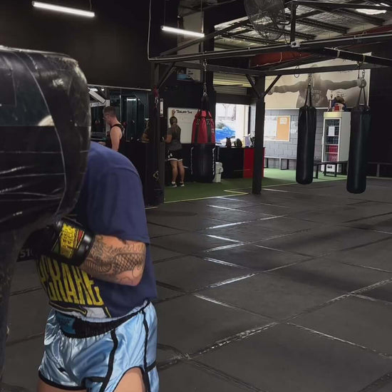 Person training with boxing equipment at a gym, showcasing Superare boxing gloves and new kit.