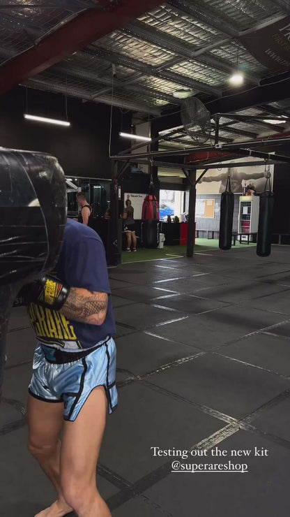 Person training with boxing equipment at a gym, showcasing Superare boxing gloves and new kit.