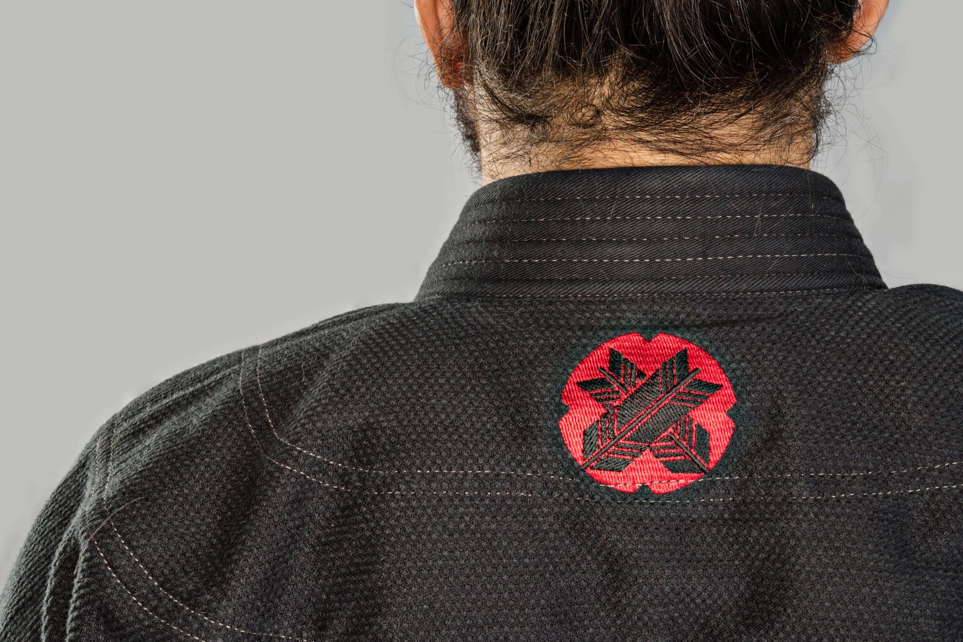 Back view of Roninbrand Samurai Ghost BJJ Gi, featuring a striking red logo on black fabric, designed for elite fighters.