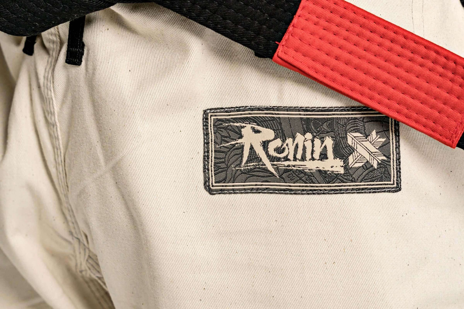 Close-up of Ronin brand BJJ gi with black and red belt, showcasing Paragon x Superare collaboration in martial arts gear.