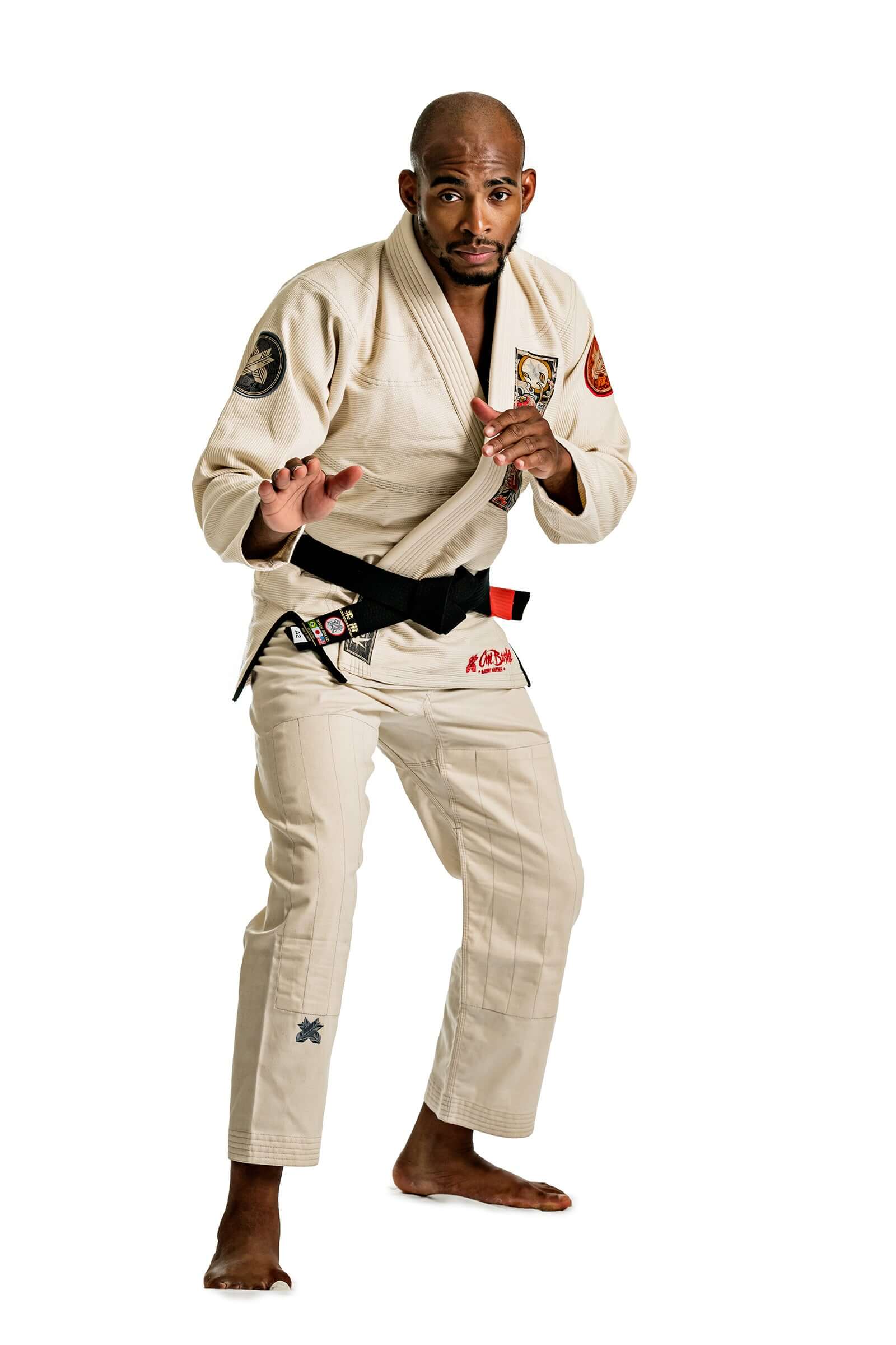 Man demonstrating grappling stance in Roninbrand Oni Bushi Unbleached BJJ Gi, showcasing martial arts techniques.